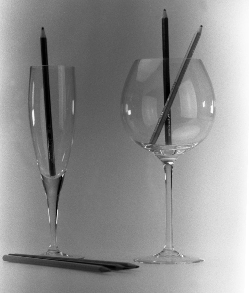 variante 1: immagine con un bicchiere da spumante ed un'altro da degustazione per vino rosso con dentro e sotto lapis colorati