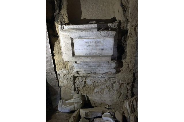dall'alto: nicchia che ospitava il busto di San Bernardino, sotto due lapidi tradotte nell'articolo e più in bassoi cocci a terra, tra cui i resti del busto di San Bernardino