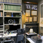 Angolo della libreria bianca con computer iMac 27" retina e spazio dedicato ai fumetti Disney più piano bianco con scanner e giradischi