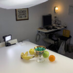 sala di posa con nello sfondo il computer MacMini Macintosh ed in primo piano la composizione di frutta, in alto un bank ottogonale con luci a basso consumo