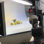 la composizione di frutta, la macchina fotografica ed i bank che si vedono abbastanza