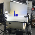 un totale sul set allestito, con due generatori flash Bowens elettronici alla base del tavolo e due Ianiro al tungsteno in fondo a destra con vari bank smontati