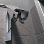 un primo piano dell'appendi abiti aperto in bagno con i ganci per appendere le pellicole ad asciugare e le stampe in B&N